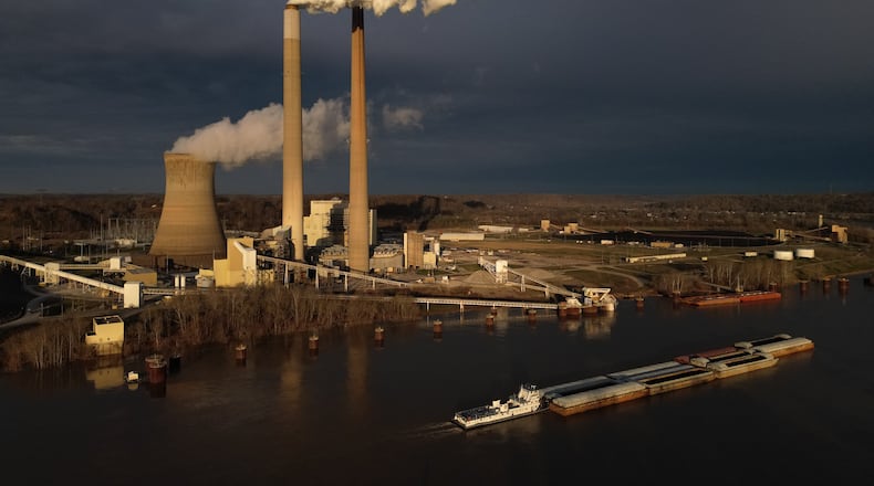 FILE - A barge on the Ohio River moves past the Mountaineer Power Plant, a coal-fired power plant near New Haven, W.Va., March 13, 2026. (AP Photo/Carolyn Kaster, File)