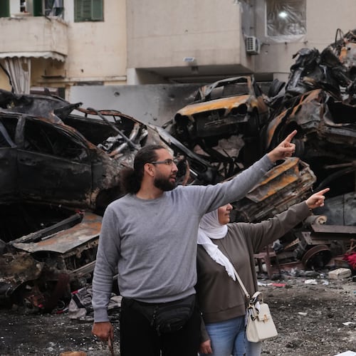 Residents gesture and point toward damage as they stand near charred cars at the site of a building destroyed in an Israeli airstrike last Wednesday in central Beirut, Lebanon, Tuesday, April 14, 2026. (AP Photo/Hassan Ammar)