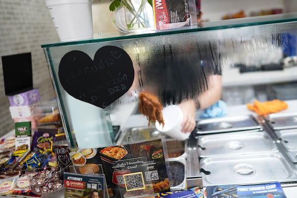 An employee serves up shredded beef for a customer inside a franchise of "Sabor Venezolano," one of 18 businesses owned by Wilmer Escaray which employ scores of Venezuelan immigrants with Temporary Protected Status (TPS) who are now potentially exposed to deportation, in Doral, Fla., Tuesday, May 20, 2025. (AP Photo/Rebecca Blackwell)