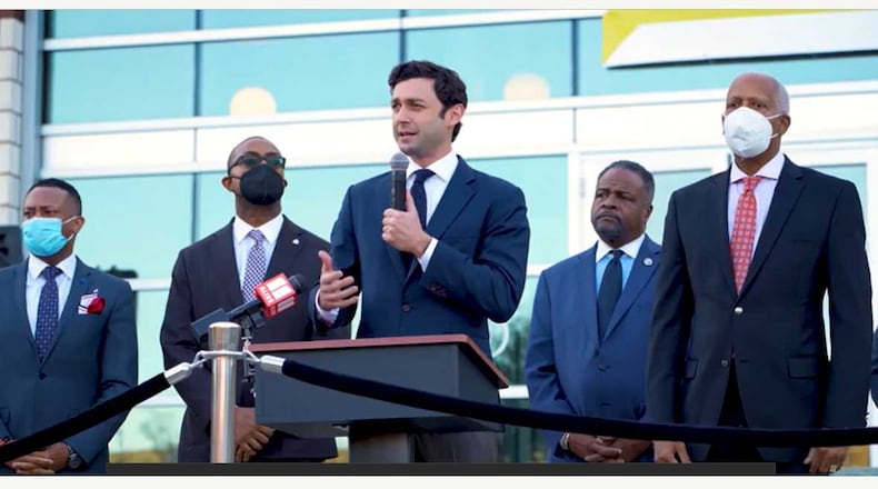 ATLANTA - U.S. Sen. Jon Ossoff, D-Ga., holding the microphone, speaks during an event on Nov. 22, 2021 outside the Atlanta University Center Robert W. Woodruff Library about legislation to provide cybersecurity training funds to historically Black colleges and universities. (Photo Credit: U.S. Sen. Jon Ossoff's office.)