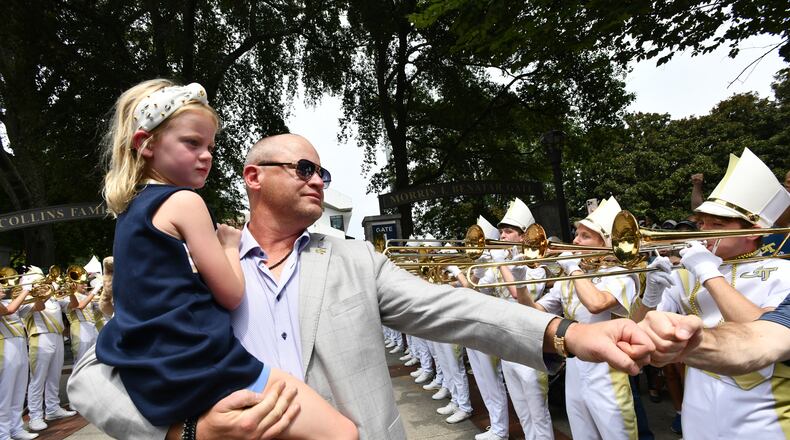 Georgia Tech coach Brent Key and his daughter, Harper, arrive with players and coaches before the home opener Sept. 6, 2025, against Gardner-Webb at Bobby Dodd Stadium in Atlanta. (Hyosub Shin/AJC)