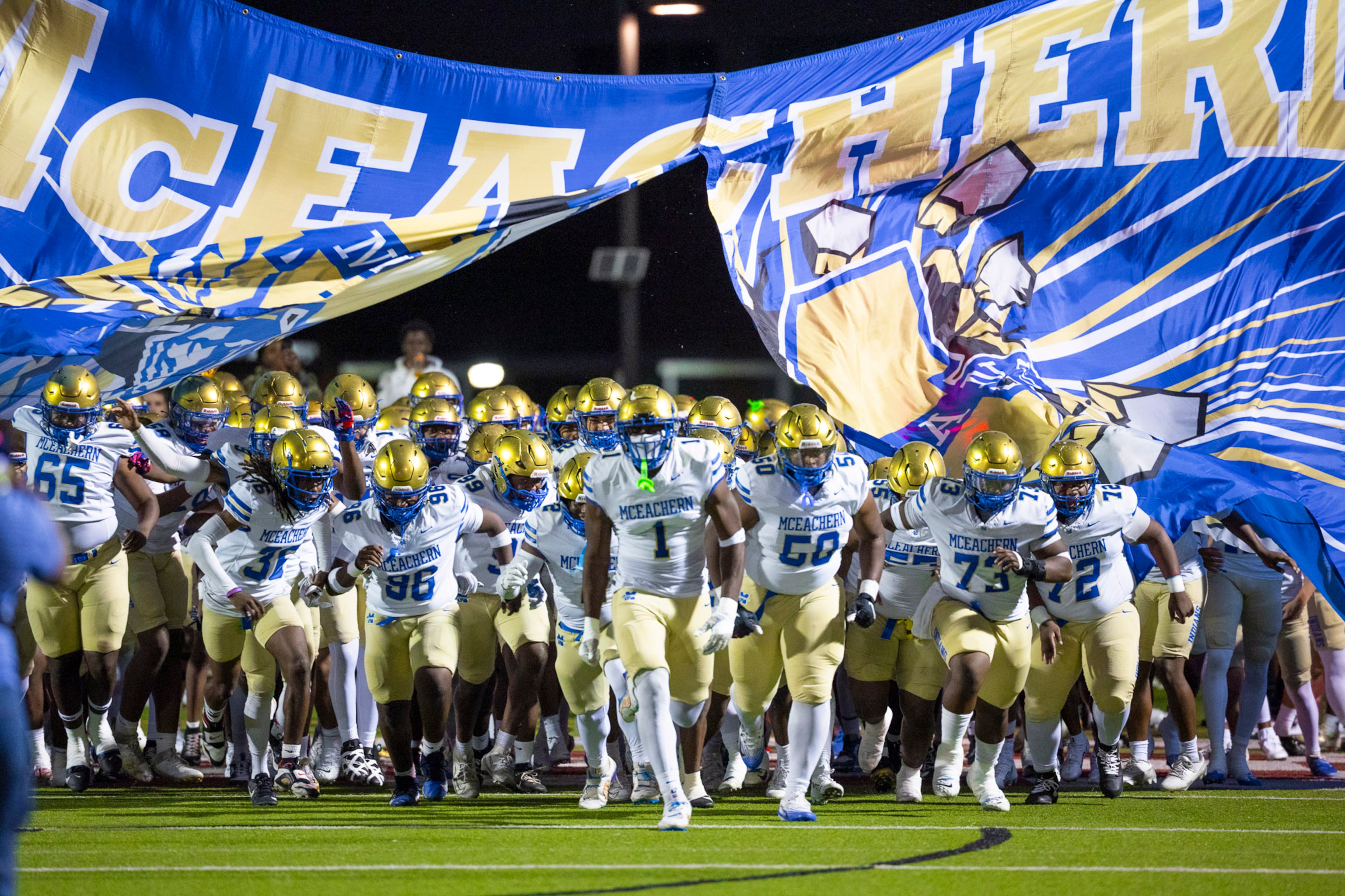 McEachern players run through the banner before the game against Hillgrove at Cobb Energy Hillgrove Stadium in Powder Springs, GA on Friday, October 17th, 2025. (Oscar Guevara Saenz for the AJC)