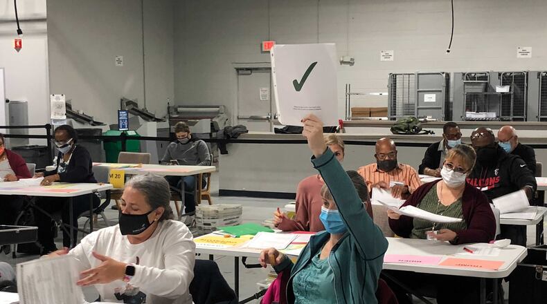 A member of a recount team in Gwinnett County holds a green check to signal they’ve counted their ballots and to receive more on Saturday, Nov. 14, 2020, at the Gwinnett elections building in Lawrenceville. J. Scott Trubey/scott.trubey@ajc.com