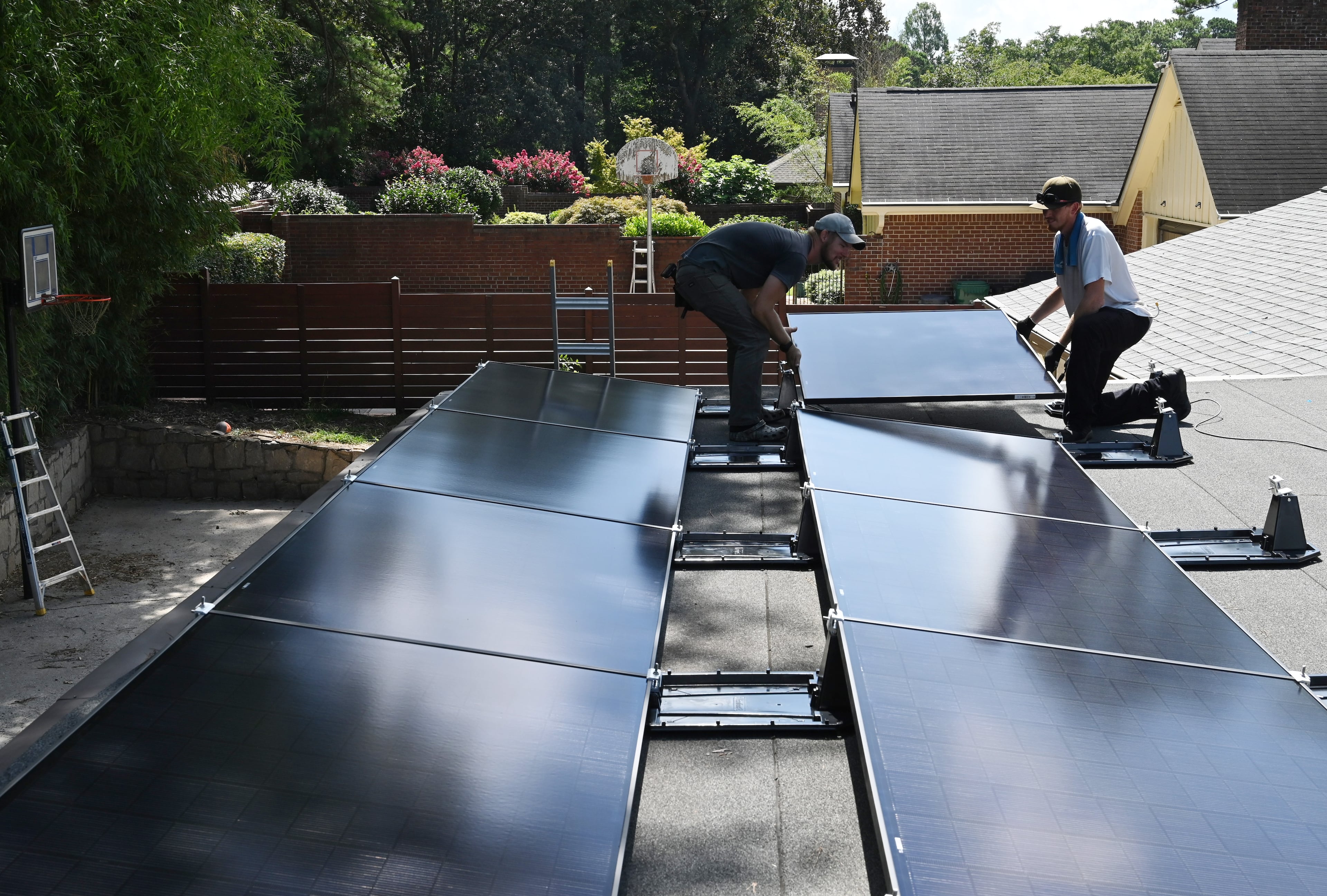 Workers for Custom Solar Solutions installed solar panels on the roof a home last month.