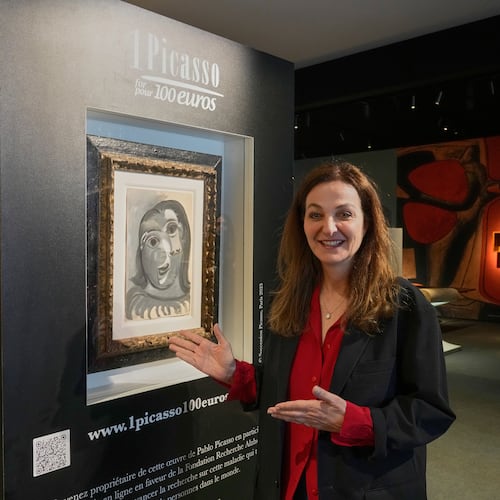 Peri Cochin, co-founder of the "1 Picasso for 100 euros" lottery, poses next to Head of a Woman by Pablo Picasso, painted in 1941, in Paris, Friday, April 10, 2026, where the draw will be handled by auction house Christie's next week. (AP Photo/Michel Euler)