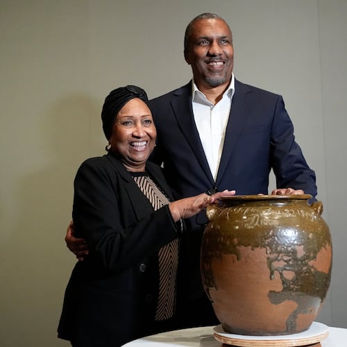 Pauline Baker and her son, Yaba Baker, pose with one of the pots created by their enslaved ancestor, David Drake, at the Museum of Fine Arts, Monday, Nov. 10, 2025, in Boston. (AP Photo/Robert F. Bukaty)
