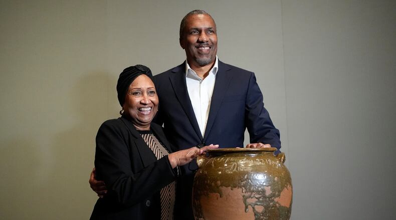Pauline Baker and her son, Yaba Baker, pose with one of the pots created by their enslaved ancestor, David Drake, at the Museum of Fine Arts, Monday, Nov. 10, 2025, in Boston. (AP Photo/Robert F. Bukaty)