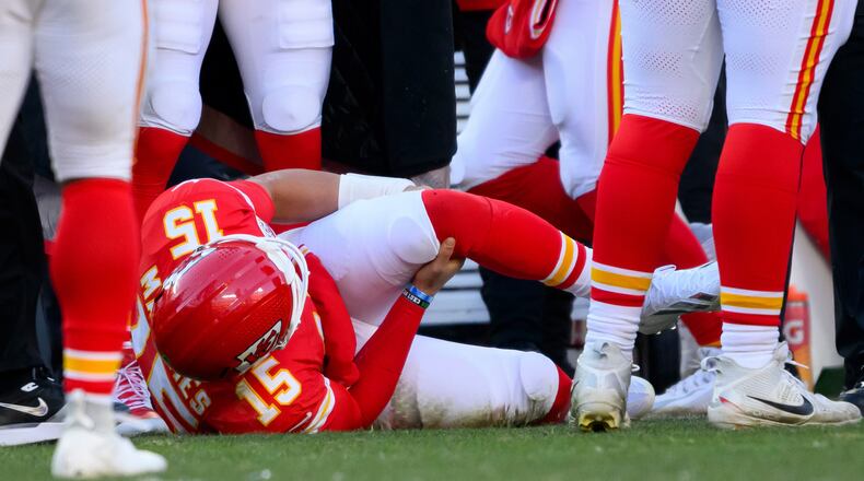 Kansas City Chiefs quarterback Patrick Mahomes grabs his knee after being injured during the second half of an NFL football game against the Los Angeles Chargers, Sunday, Dec. 14, 2025 in Kansas City, Mo. (AP Photo/Reed Hoffmann)