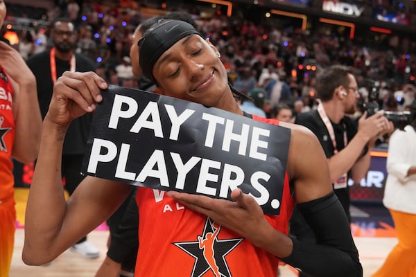 Washington Mystics' Brittney Sykes holds a sign following a WNBA All-Star basketball game against Team Collier, Saturday, July 19, 2025, in Indianapolis. (AP Photo/Michael Conroy)