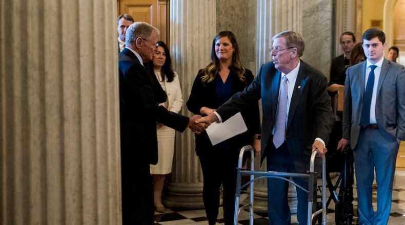 UNITED STATES - DECEMBER 3: Sen. Johnny Isakson, R-Ga., right, shakes hands with Sen. Jim Inhofe, R-Okla., as he walks to the Senate floor to deliver his farewell address in the Capitol on Tuesday, Dec. 3, 2019. (Photo By Bill Clark/CQ Roll Call via AP Images)