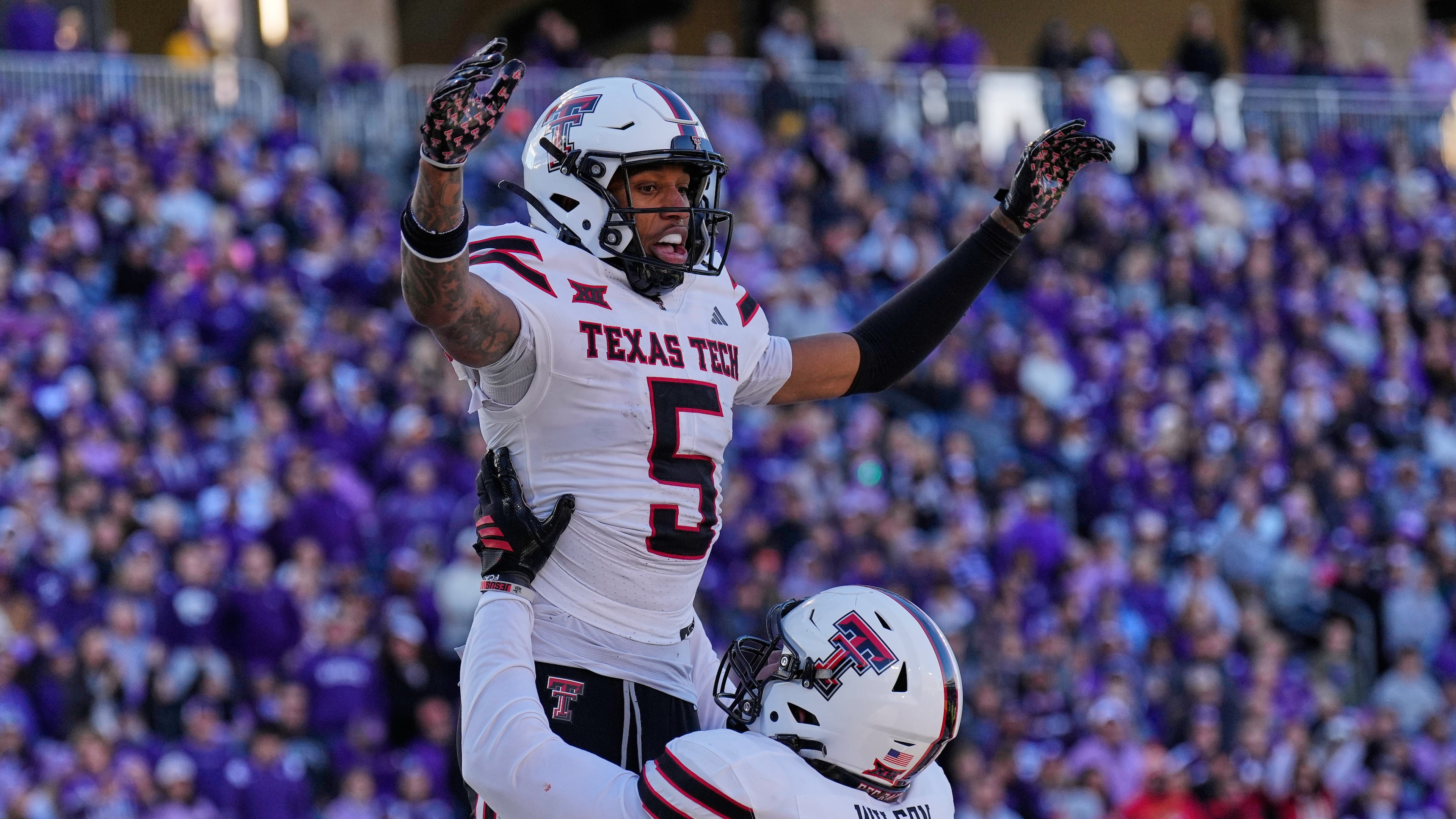 Texas Tech wide receiver Caleb Douglas (5) celebrates with offensive lineman Sheridan Wilson after scoring a touchdown during the second half of an NCAA college football game against Kansas State, Saturday, Nov. 1, 2025, in Manhattan, Kan. (AP Photo/Charlie Riedel)