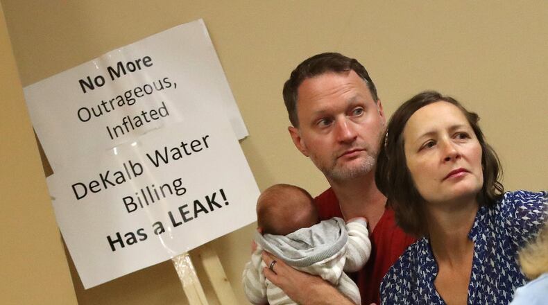Matt and Star McKenizie, with newborn son Everett, were among DeKalb residents demanding answers about excessively high water bills during a town hall meeting at the Maloof Auditorium in Decatur on Nov. 10.  Curtis Compton/ccompton@ajc.com