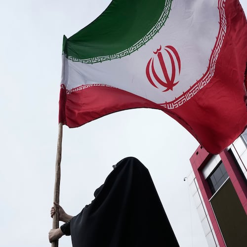 A woman holds an Iranian flag for a pro-government campaign in downtown Tehran, Iran, Saturday, April 25, 2026. (AP Photo/Vahid Salemi)