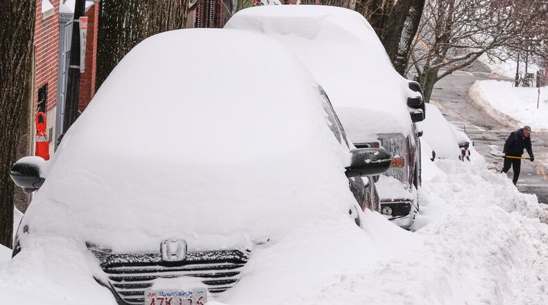 A man digs a car out of the snow on Beacon Hill following a winter storm that dumped more than a foot of snow across the region, Monday, Jan. 26, 2026, in Boston. (AP Photo/Charles Krupa)