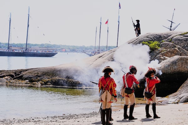 British soldiers on the beach engage a Colonial soldier during a reenactment in celebration of the 250th anniversary of the Battle of Bunker Hill, Saturday, June 21, 2025, in Gloucester, Mass. (AP Photo/Charles Krupa)
