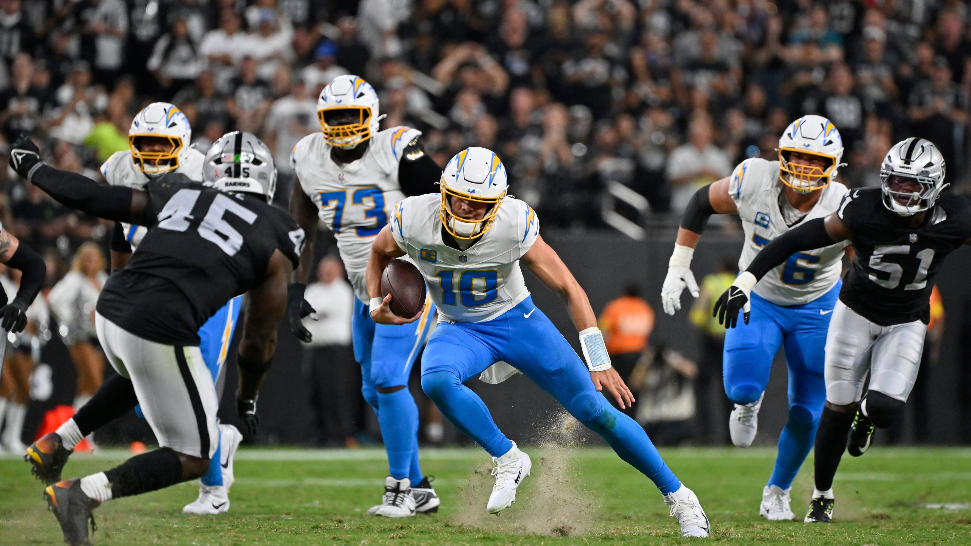 Los Angeles Chargers quarterback Justin Herbert (10) runs with the ball against the Las Vegas Raiders during the first half of an NFL football game, Monday, Sept. 15, 2025, in Las Vegas. (AP Photo/David Becker)