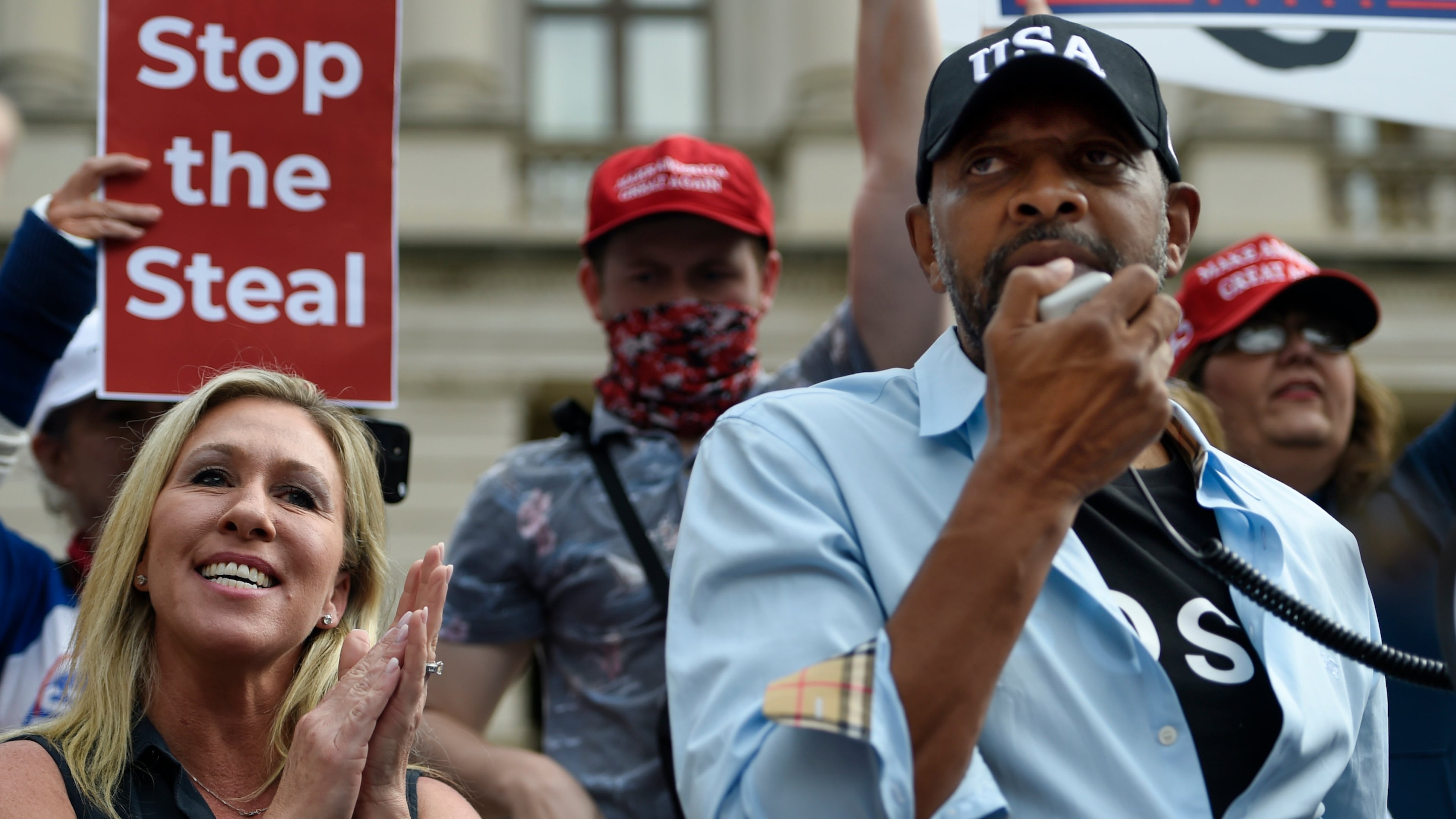 President Donald Trump supporters cheer as Georgia state Rep. Vernon Jones speaks as Marjorie Taylor Greene looks on, Saturday, Nov. 7, 2020, in Atlanta. (AP Photo/Mike Stewart)