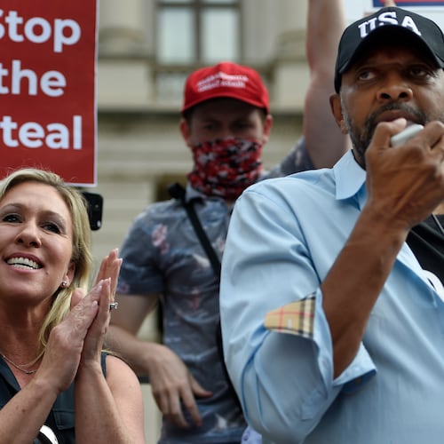 President Donald Trump supporters cheer as Georgia state Rep. Vernon Jones speaks as Marjorie Taylor Greene looks on, Saturday, Nov. 7, 2020, in Atlanta. (AP Photo/Mike Stewart)