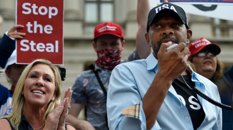 President Donald Trump supporters cheer as Georgia State Rep. Vernon Jones speaks as Marjorie Taylor Greene looks on, Saturday, Nov. 7, 2020, in Atlanta. (AP Photo/Mike Stewart)
