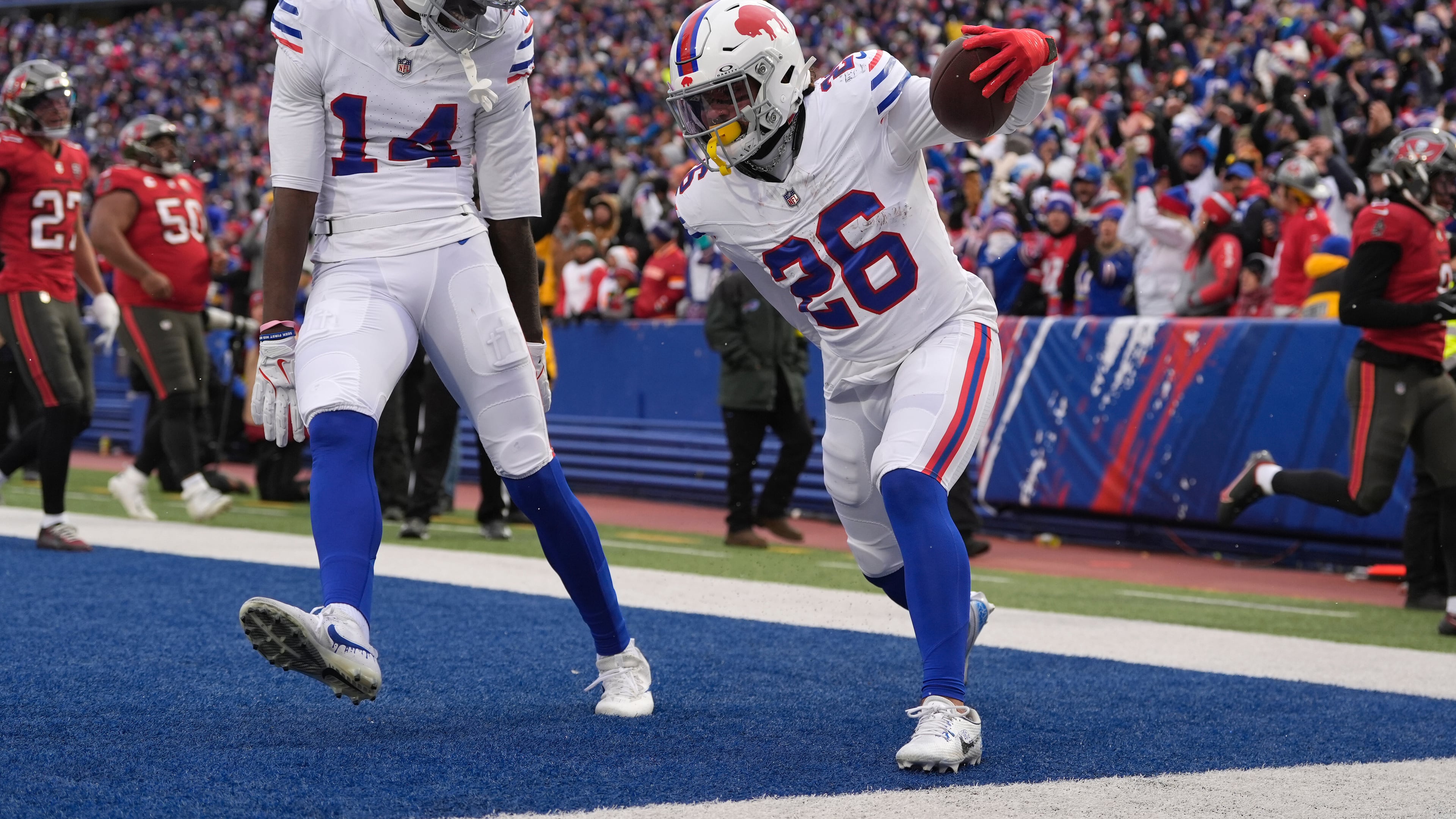 Buffalo Bills running back Ty Johnson (26) celebrates with wide receiver Tyrell Shavers (14) after scoring a touchdown against the Tampa Bay Buccaneers during the first half of an NFL football game, Sunday, Nov. 16, 2025, in Orchard Park, N.Y. (AP Photo/Carolyn Kaster)