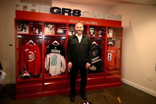 Washington Capitals left wing Alex Ovechkin poses by a locker display at the GR8 city celebration to honor him for scoring 895 NHL hockey career goals, Friday, April 11, 2025, in Washington. (AP Photo/Nick Wass)