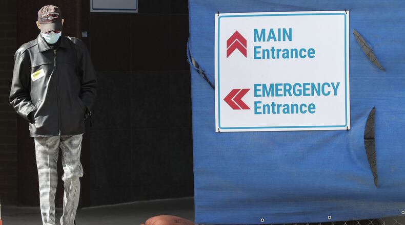 A man wearing a “screened” sticker exits Grady Memorial Hospital April 1, 2020. JOHN SPINK/JSPINK@AJC.COM