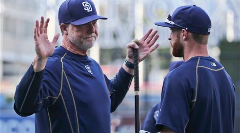 San Diego Padres bench coach Mark McGwire has a discussion with second baseman Cory Spangenberg prior to a baseball game against the Arizona Diamondbacks Friday, April 15, 2016, in San Diego. (AP Photo/Lenny Ignelzi)