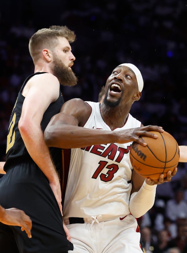 Cleveland Cavaliers forward Dean Wade, left, defends against Miami Heat center Bam Adebayo (13) during the first half in Game 4 of an NBA basketball first-round playoff series, Monday, April 28, 2025, in Miami. (AP Photo/Rhona Wise)