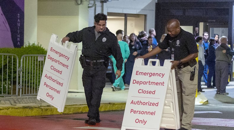 Security guards set out signs in front of the hospital after the emergency room at Wellstar Atlanta Medical Center closed in Atlanta Friday morning, October 14, 2022. (PHOTO by Steve Schaefer/steve.schaefer@ajc.com)