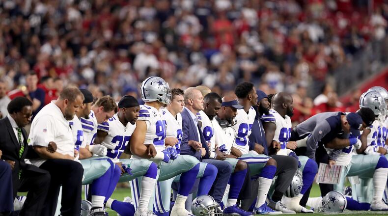 GLENDALE, AZ - SEPTEMBER 25: Members of the Dallas Cowboys link arms and kneel during the National Anthem before the start of the NFL game against the Arizona Cardinals at the University of Phoenix Stadium on September 25, 2017 in Glendale, Arizona. (Photo by Christian Petersen/Getty Images)