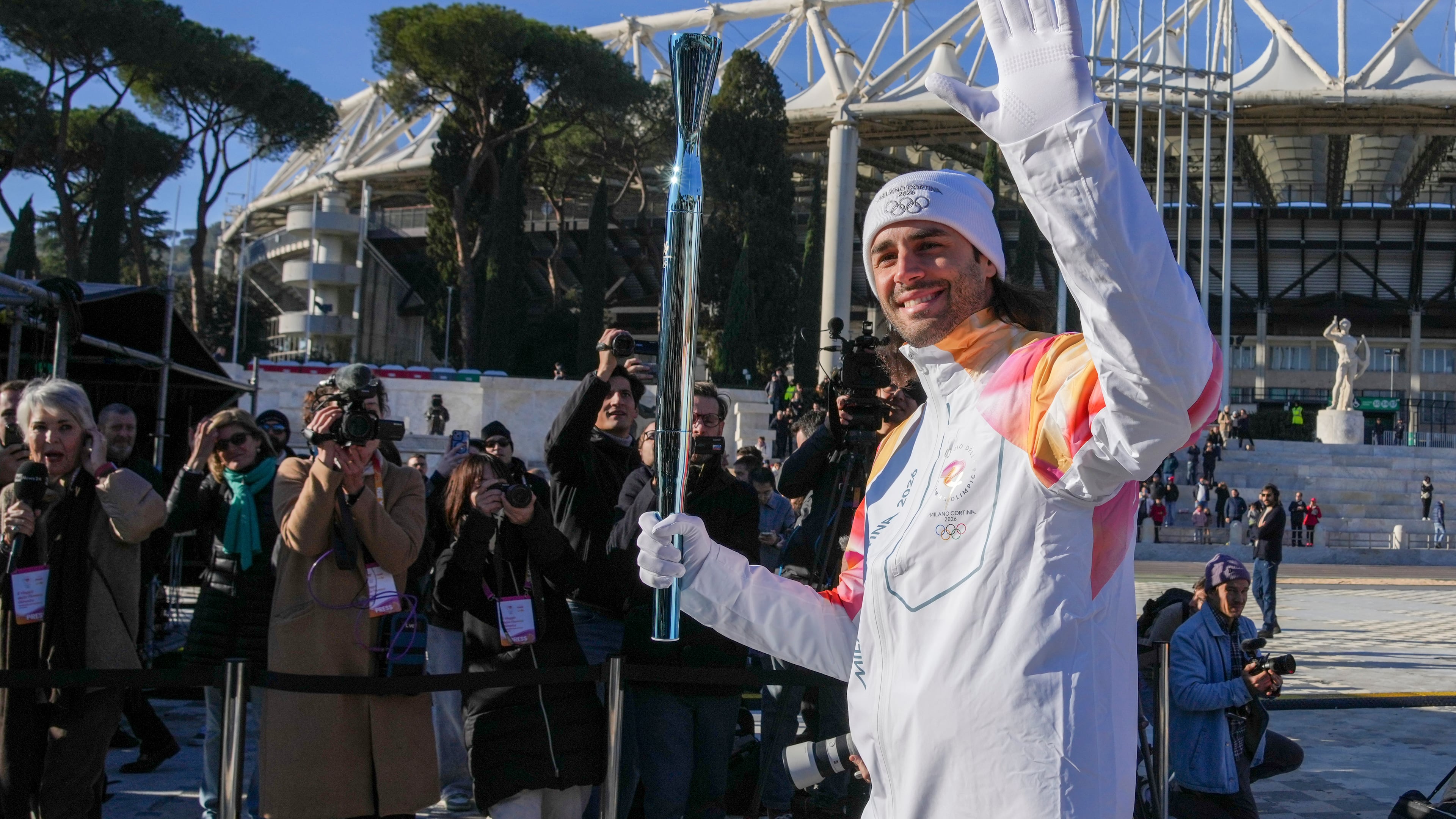 Italian swimmer Gregorio Paltrinieri carries the 2026 Milan Cortina Winter Olympics torch in Rome as it begins its journey through Italy, Saturday, Dec. 6, 2025, a journey that will conclude in Milan in February 2026. (AP Photo/Andrew Medichini)