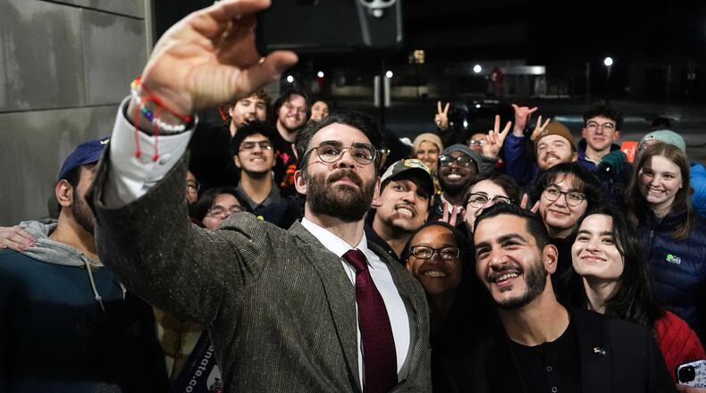Streamer Hasan Piker, left, and Abdul El-Sayed, a progressive candidate in the Democratic primary for U.S. Senate in Michigan, center right, take a selfie with young fans following a campaign event, Tuesday, April 7, 2026, at the University of Michigan in Ann Arbor, Mich. (AP Photo/Julia Demaree Nikhinson)