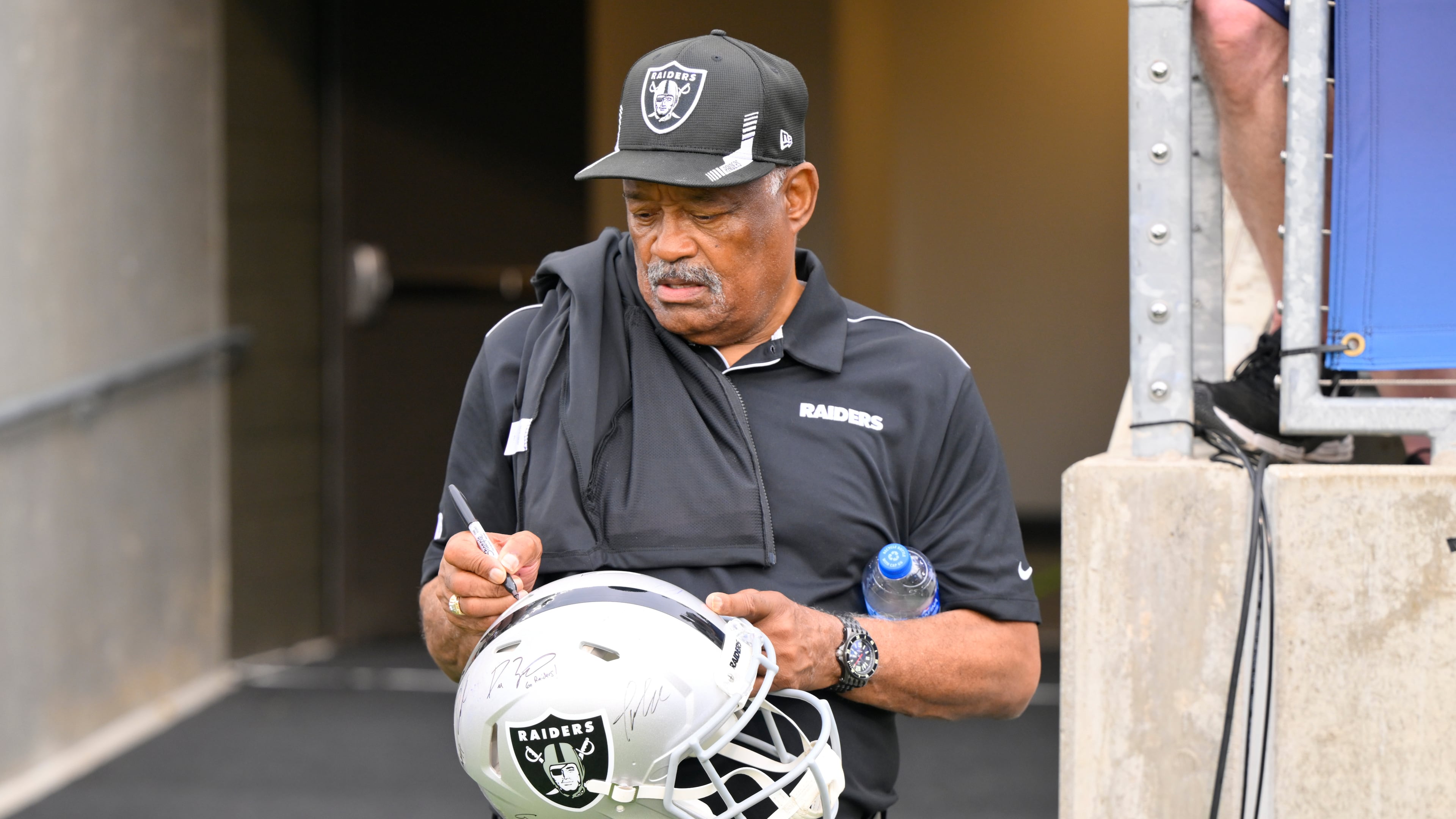 FILE - Former Oakland Raiders safety George Atkinson signs his autograph before the NFL football exhibition Hall of Fame Game between the Las Vegas Raiders and the Jacksonville Jaguars, Aug. 4, 2022, in Canton, Ohio. (AP Photo/David Richard, file)