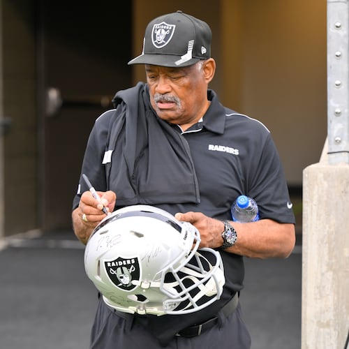 FILE - Former Oakland Raiders safety George Atkinson signs his autograph before the NFL football exhibition Hall of Fame Game between the Las Vegas Raiders and the Jacksonville Jaguars, Aug. 4, 2022, in Canton, Ohio. (AP Photo/David Richard, file)