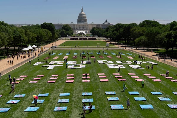 An installation titled "Freedom To Be," including more than 250 quilt panels handmade by transgender people and their families from across the country, is unveiled by The American Civil Liberties Union and the Gender Liberation Movement on the National Mall, Saturday, May 17, 2025, in Washington. (AP Photo/Jose Luis Magana)