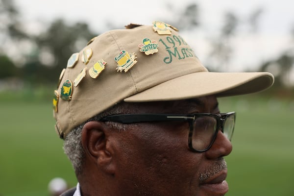 Cleveland Crumbley, of Atlanta, watches the golfers on the second green during a practice round at the Masters golf tournament Monday, April 6, 2026 in Augusta. Crumbley has been to more than 20 Masters tournaments and always buys a pin from each tournament and places them on his hat. (Jason Getz/AJC) 