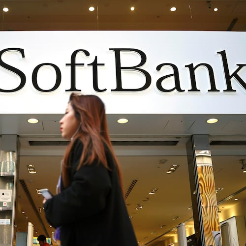 FILE - A woman walks in front of SoftBank store in Ginza shopping district in Tokyo, Jan. 20, 2020. (AP Photo/Eugene Hoshiko, File)