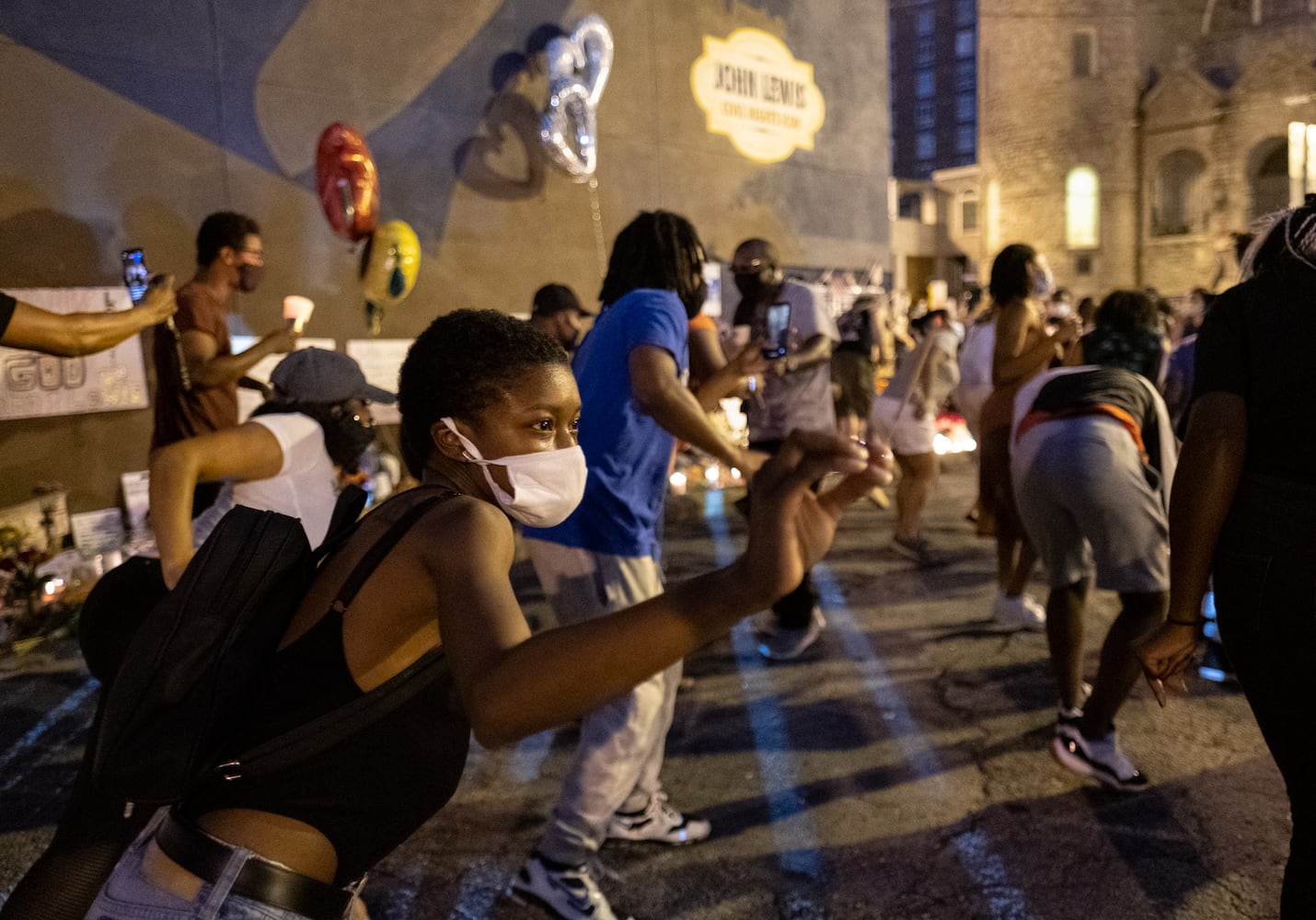 Ebony Carter of McDonough, who is running for the state House in District 110, joins an impromptu line dance below the John Lewis mural in downtown Atlanta on Sunday evening July 19, 2020, during a celebration of the congressman's life. (Photo: Ben Gray for The Atlanta Journal-Constitution)