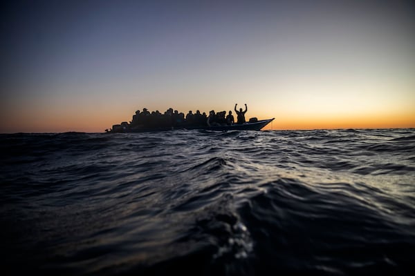 FILE - Migrants and refugees wait for assistance on an overcrowded wooden boat in the Mediterranean Sea off the Libyan coast, Feb. 12, 2021. (AP Photo/Bruno Thevenin, File)