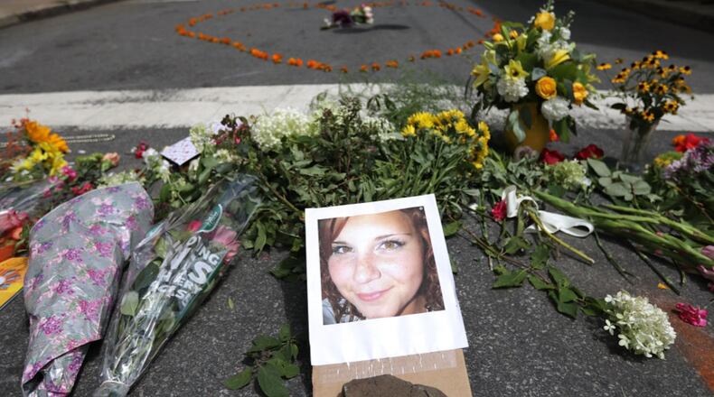 CHARLOTTESVILLE, VA - AUGUST 13:   Flowers surround a photo of 32-year-old Heather Heyer, who was killed when a car plowed into a crowd of people protesting against the white supremacist Unite the Right rally, August 13, 2017 in Charlottesville, Virginia. Charlottesville is calm the day after violence errupted around the Unite the Right rally, a gathering of white supremacists, that left Heyer dead and injured 19 others.
