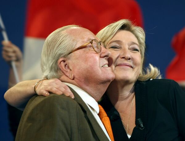 FILE - Honorary President of far-right party National Front Jean-Marie Le Pen, left, and his daughter French far-right leader and National Front Party candidate for the 2012 French presidential elections, Marine Le Pen, react during a campaign meeting, in Marseille, southern France, March 4, 2012. (AP Photo/Claude Paris, File)
