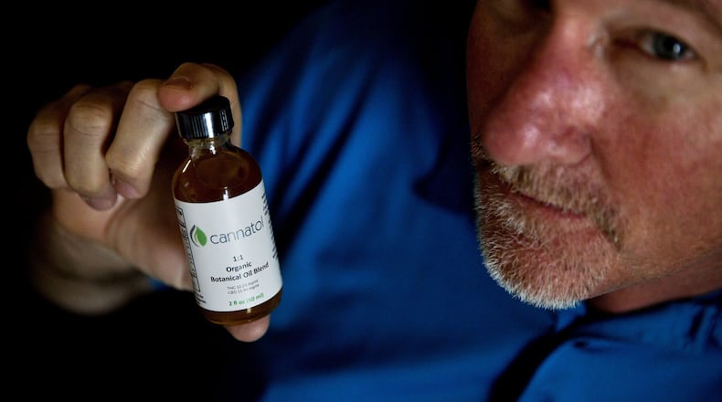 Georgia state Rep. Allen Peake, R-Macon, displays a bottle of cannabis oil in his office in Macon. Peake, the author of the bill that began the state’s medical marijuana program, still hopes one day the state will allow the production of the oil within Georgia’s borders. (AP Photo/David Goldman)
