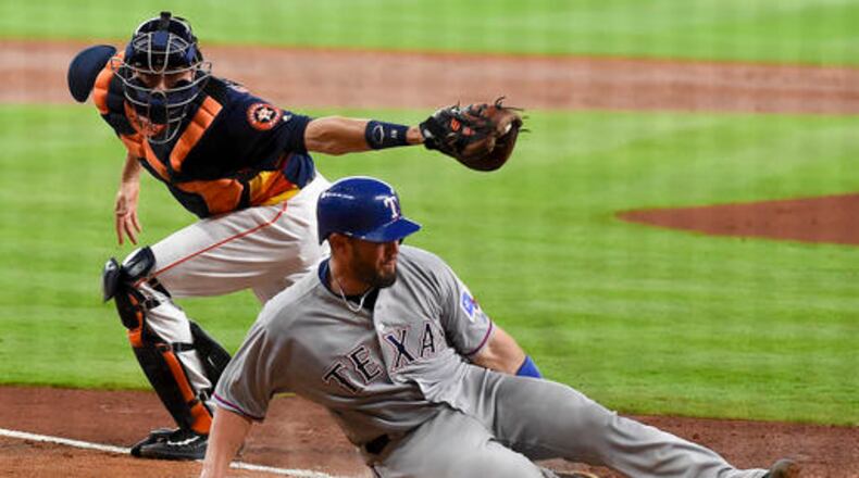 Texas Rangers' Bobby Wilson, right, beats the tag of Houston Astros catcher Jason Castro to score a run on Ian Desmond's RBI single during the third inning of a baseball game, Sunday, May 22, 2016, in Houston. (AP Photo/Eric Christian Smith)