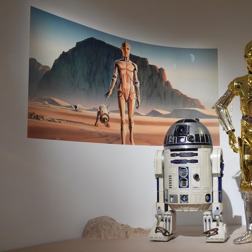 Production designer Norman Reynolds' robot R2-D2, left, and John Mollo's costume for the C-3PO character from the "Star Wars" franchise are displayed in the Cinema Gallery during a preview of the Lucas Museum of Narrative Art on Monday, Aug. 31, 2026, in Los Angeles. (AP Photo/Chris Pizzello)