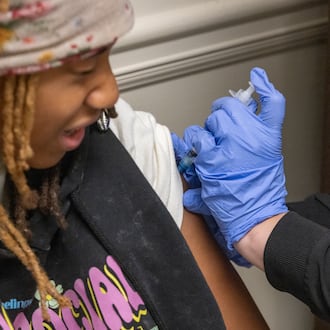 Liah Pinkett, 14, got a back-to-school vaccine shot in July 2025. The CDC no longer recommends the flu vaccine for all children. (Arvin Temkar/AJC)