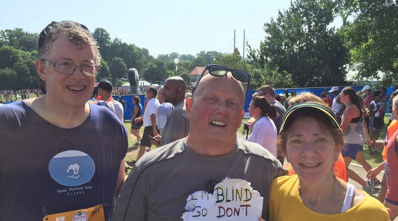 Dan Toney (Buckhead, L) and Rose Marie Inserni (Buckhead, R) help Robert Swain (Atlanta, M) run the AJC Peachtree Road. (Alex Makrides)