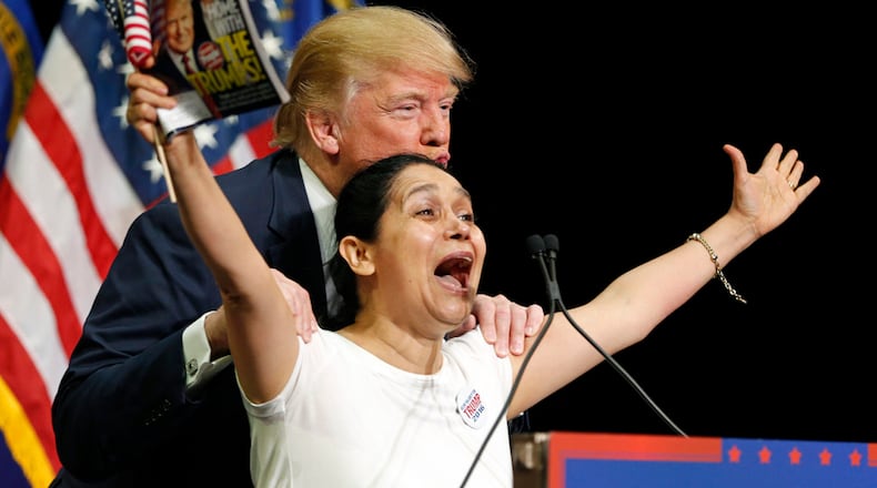 Republican presidential candidate Donald Trump kisses a woman who he brought up on stage during a rally on Thursday in Las Vegas. Later, the front-runner tweeted: "Just leaving Las Vegas. Unbelievable crowd! Many Hispanics who love me and I love them!"