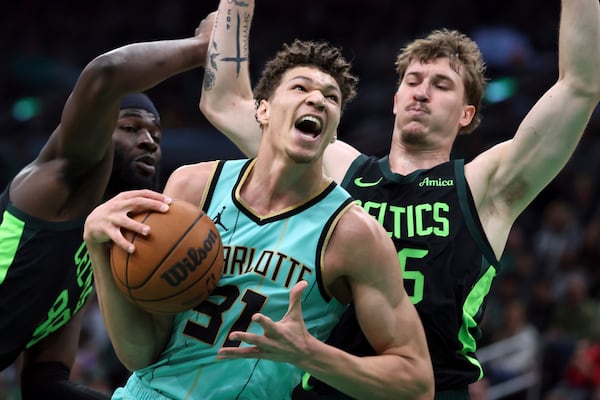 Charlotte Hornets' Tidjane Salaun (31) drives for the basket against Boston Celtics' Neemias Queta (88) and Baylor Scheierman (55) during the first half of an NBA basketball game Sunday, April 13, 2025, in Boston. (AP Photo/Michael Dwyer)