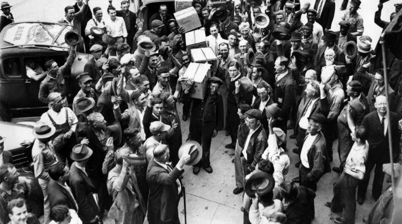 A crowd cheers arrival of the first legal stock of liquor at Marietta on April 22, 1935. A store on the Court House Square was all ready for the gala opening at 10 a.m. that Friday morning but there wasn't a bottle on the shelves. Half an hour later 100 cases arrived by truck from a Columbus state warehouse. AJC Photo Archive