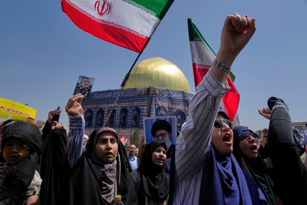 Iranian protesters chant slogans as one of them holds up a portrait of Iran's Revolutionary Guard aerospace division commander, Gen. Amir Ali Hajizadeh, who was killed in an Israeli strike on Iran, in front of a model of Jerusalem's Dome of the Rock mosque, during a protest to condemn Israeli attacks on multiple cities across Iran, after Friday prayers ceremony in Tehran, Iran, Friday, June 20, 2025. (AP Photo/Vahid Salemi)